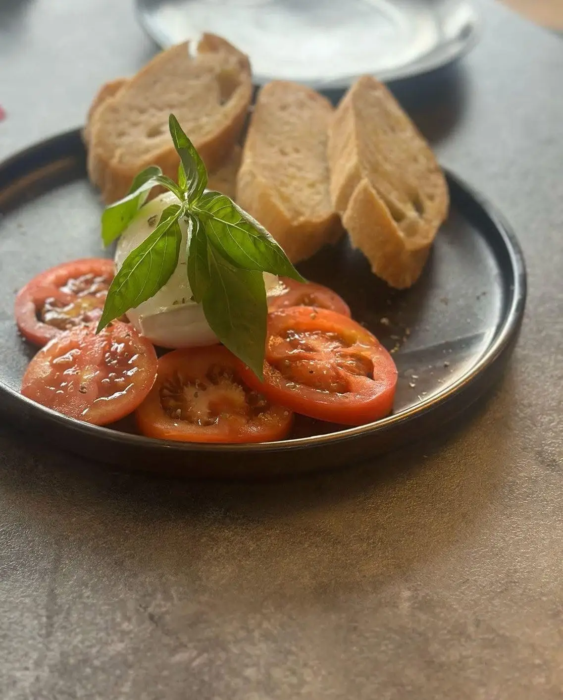Mozzarella with basil on sliced tomato, olive oil and toasted bread