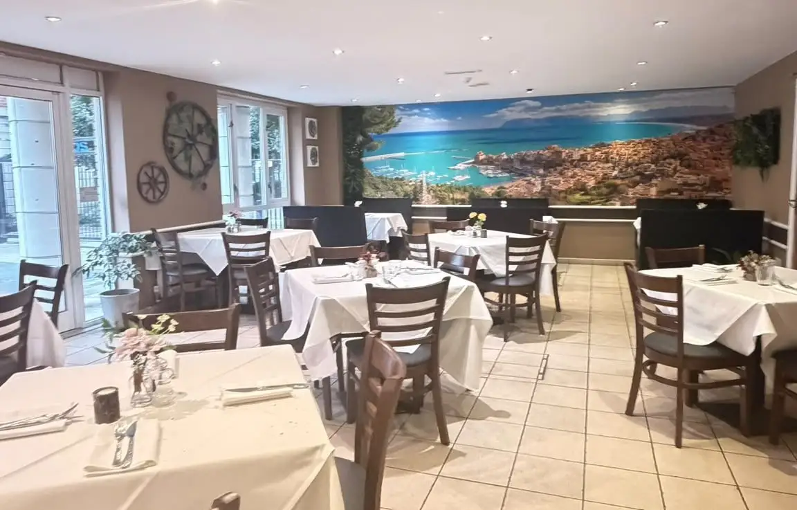 Dining room with cart wheels on the wall and a panoramic mural of the sea